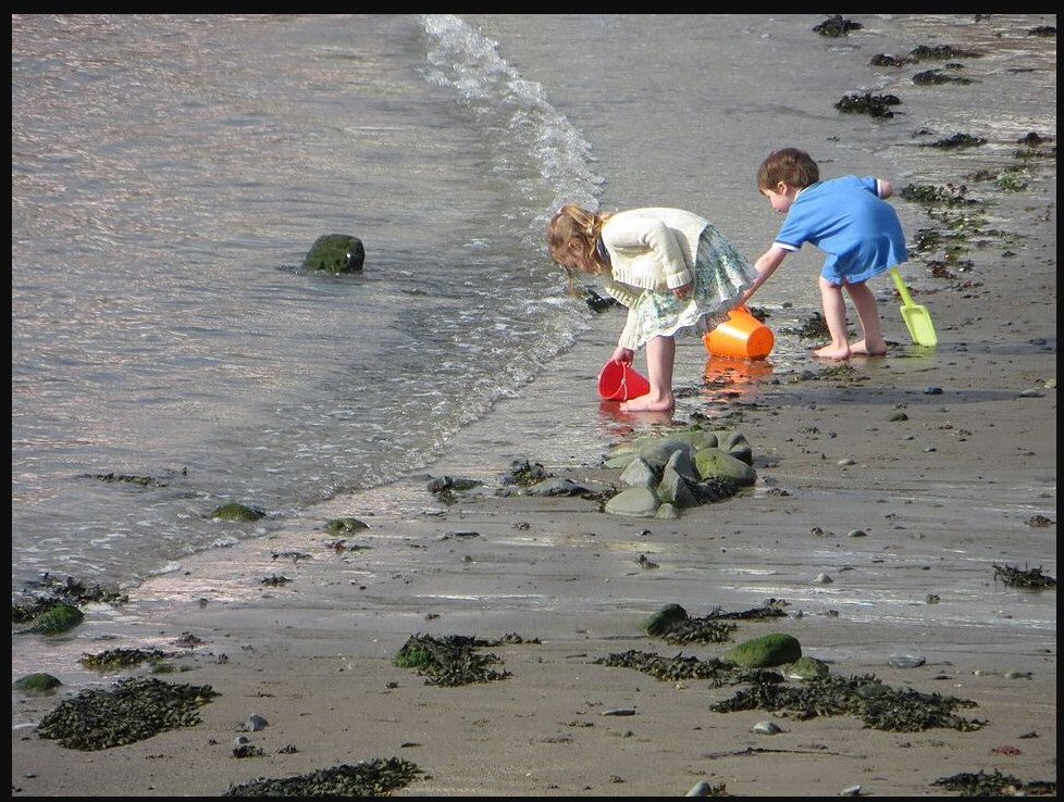 Crianças brincando na praia durante passeio em família